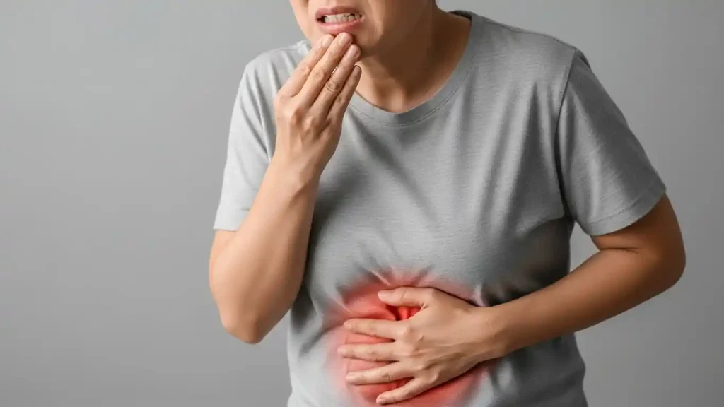Patient experiencing tooth pain while holding their stomach, representing how a dental infection or decaying tooth can lead to nausea and stomach discomfort.